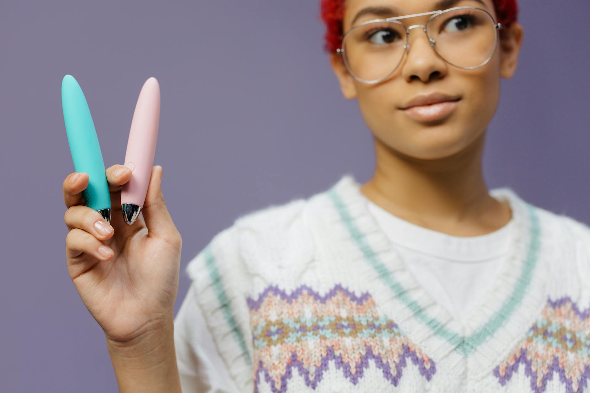 Woman holding colorful vibrators, exploring sensation and pleasure options