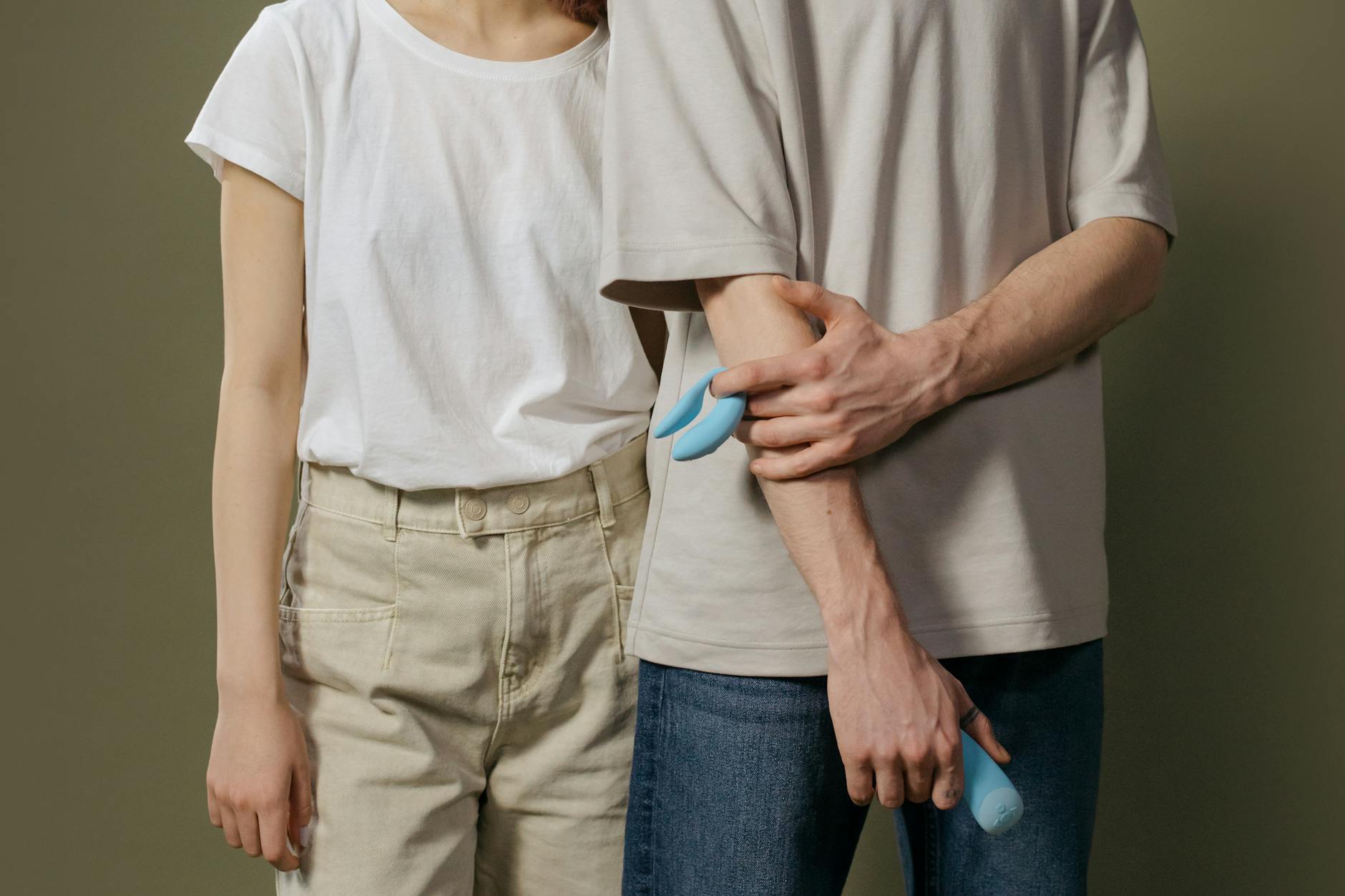 A young couple standing together indoors discussing intimacy and toys