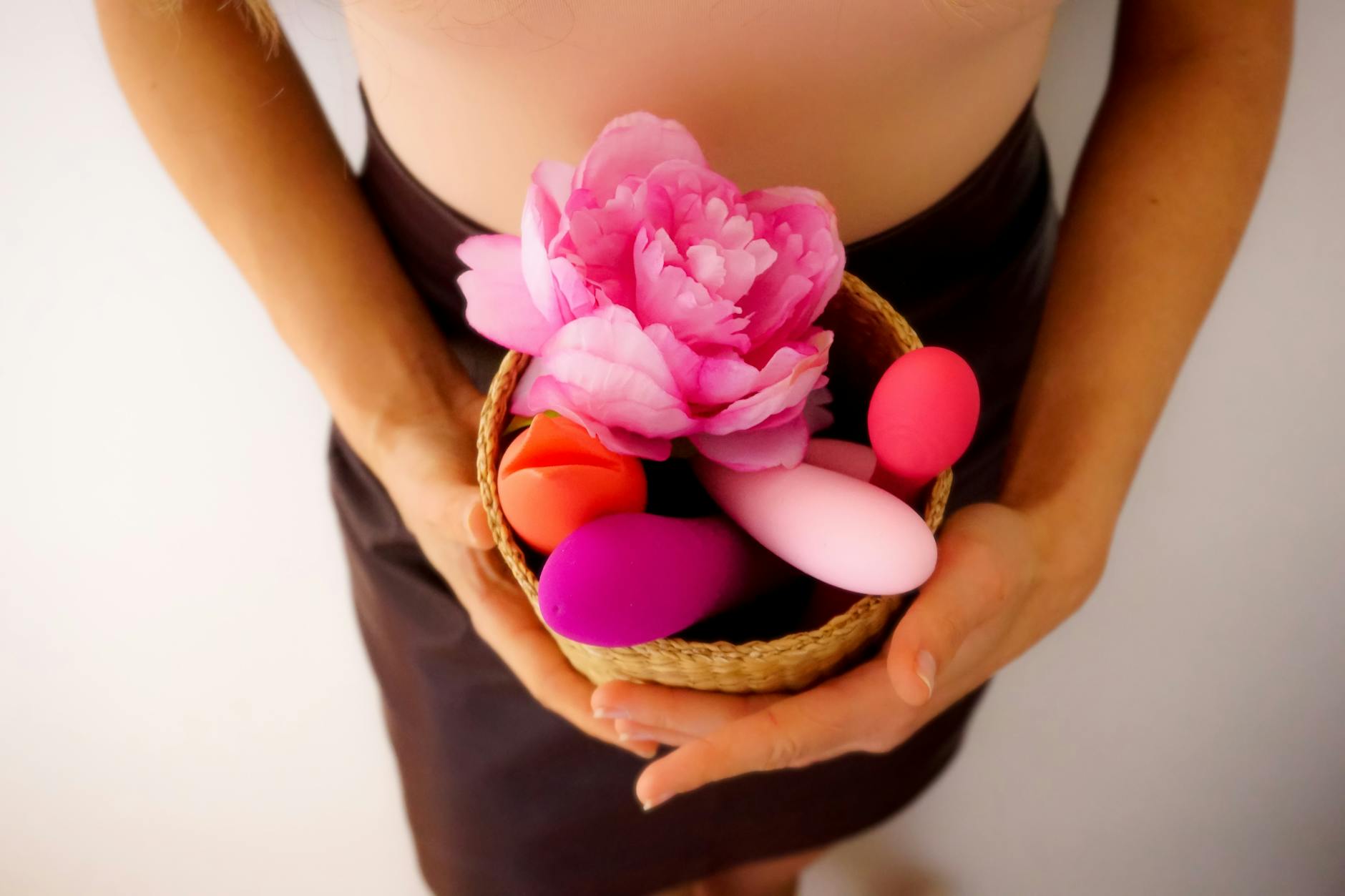 Hand reaching over colorful vibrators arranged on a table